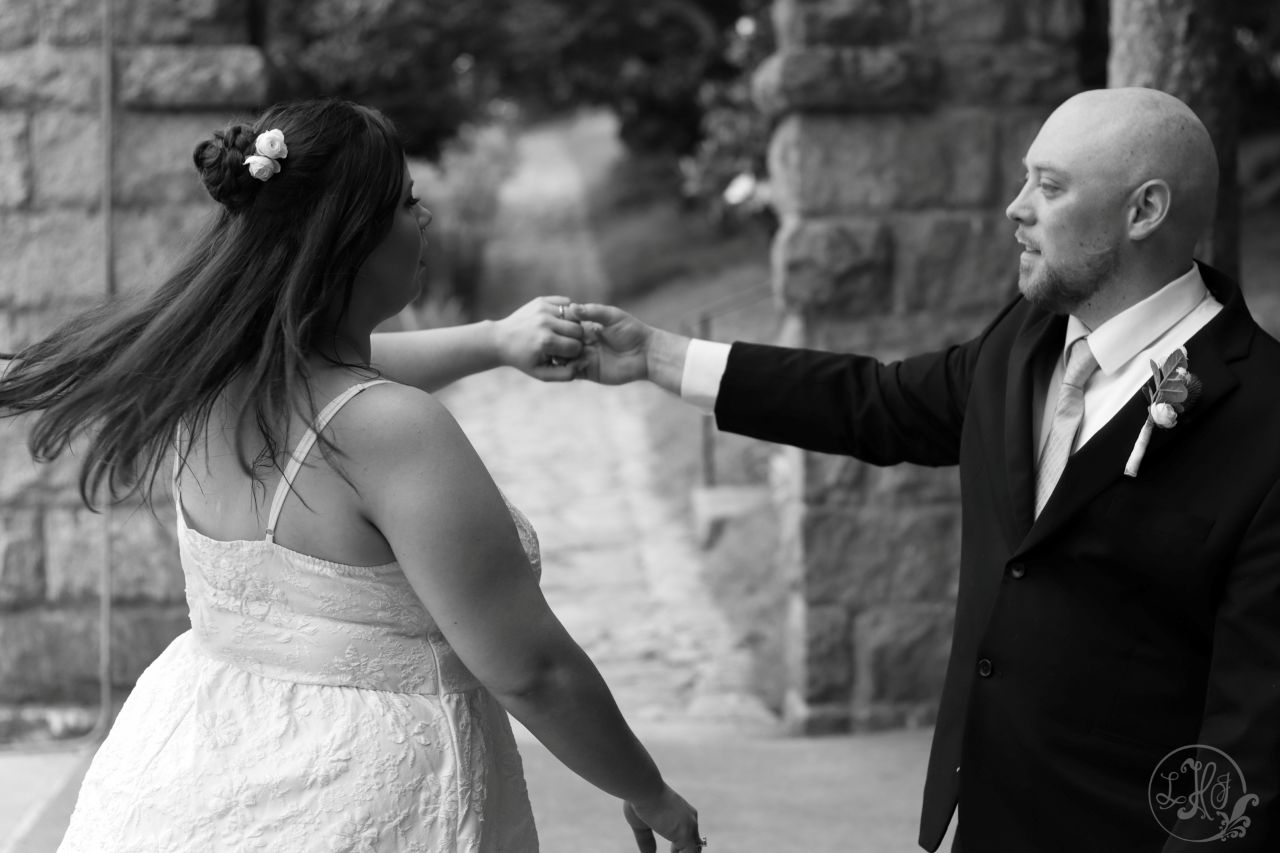 Black and white photo of groom twirling bride