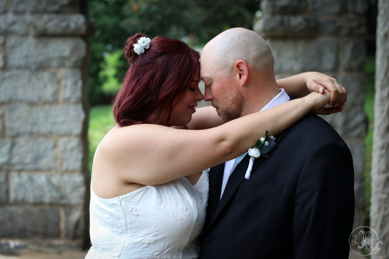 Bride wraps arms around groom's neck as they look into each others' eyes