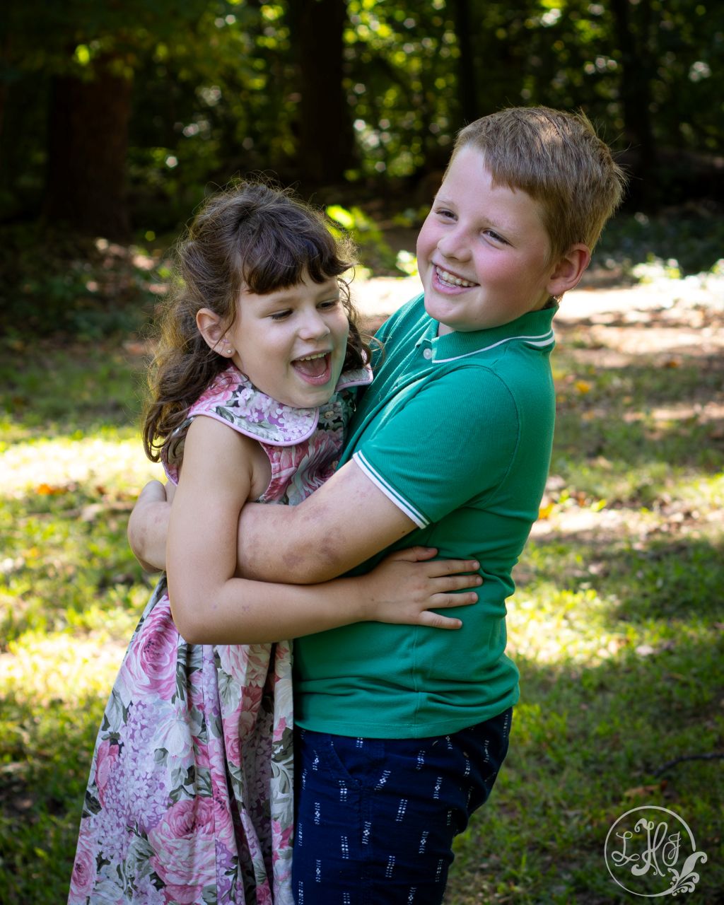 Brother bear-hugging little sister