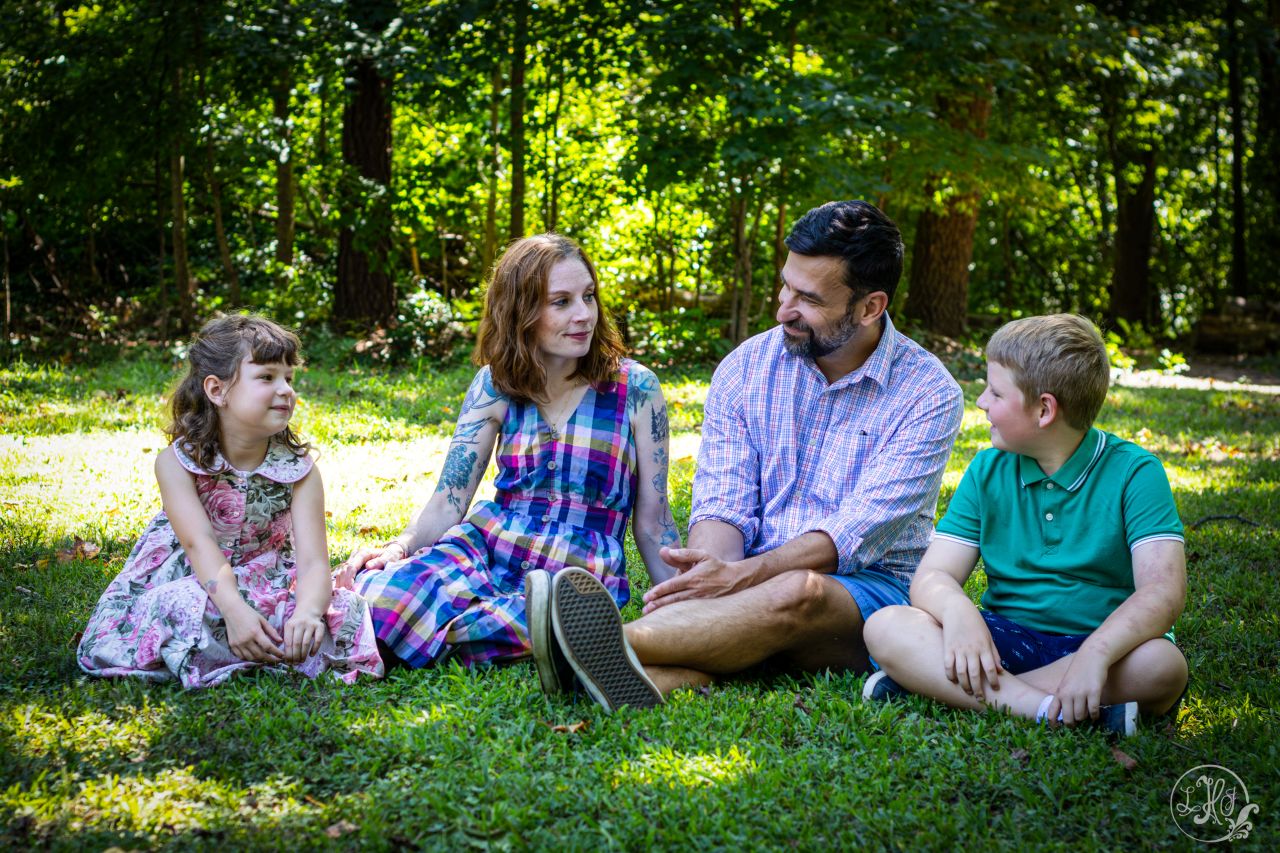 family of 4 sitting in grass