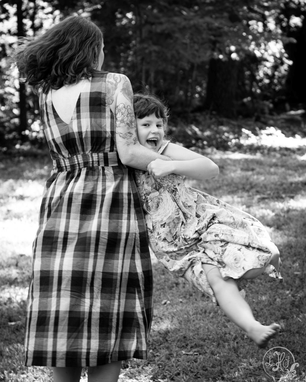 Black and white photo of mother spinning daughter around