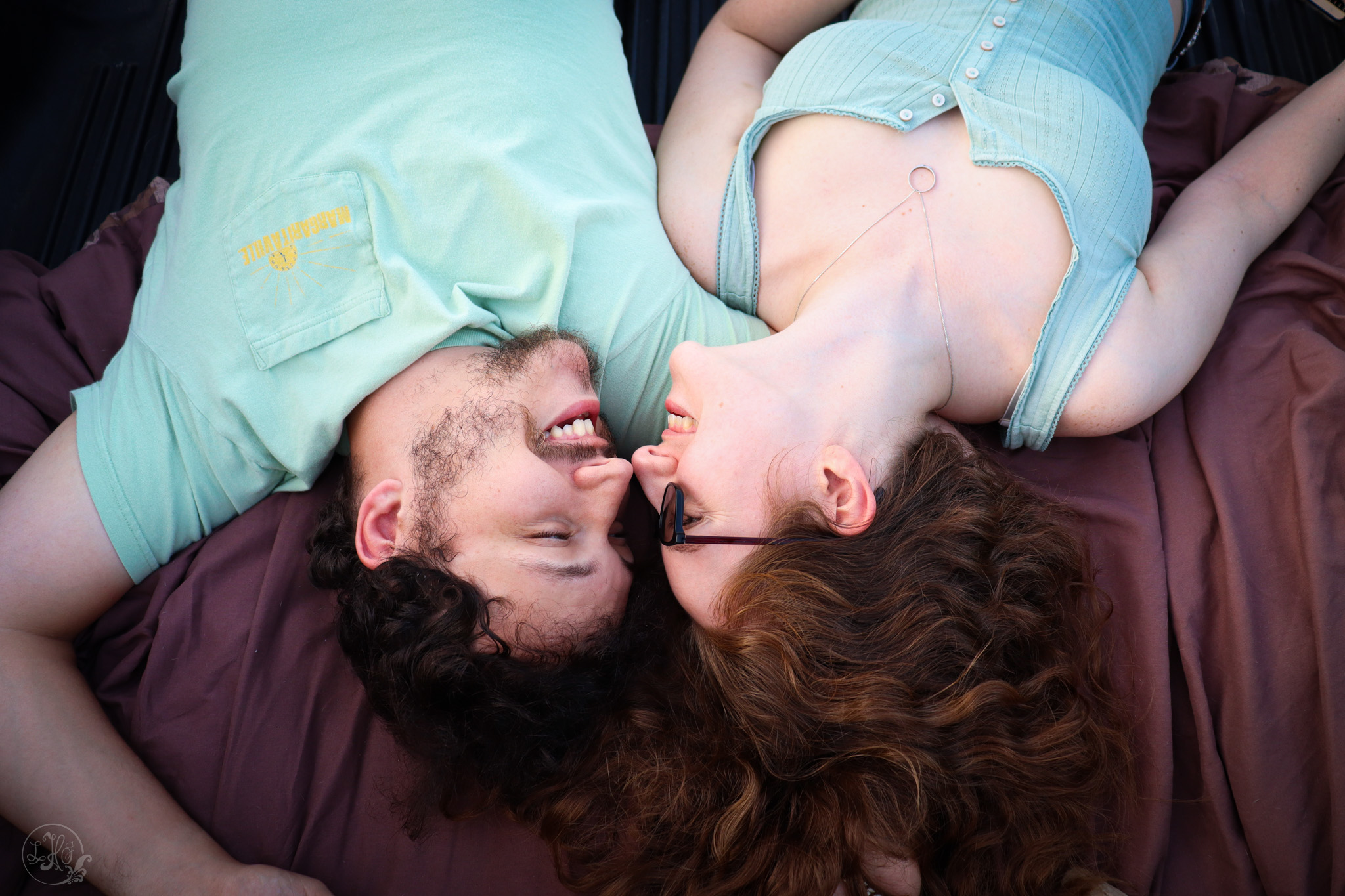 photo of couple laying down and looking at each other