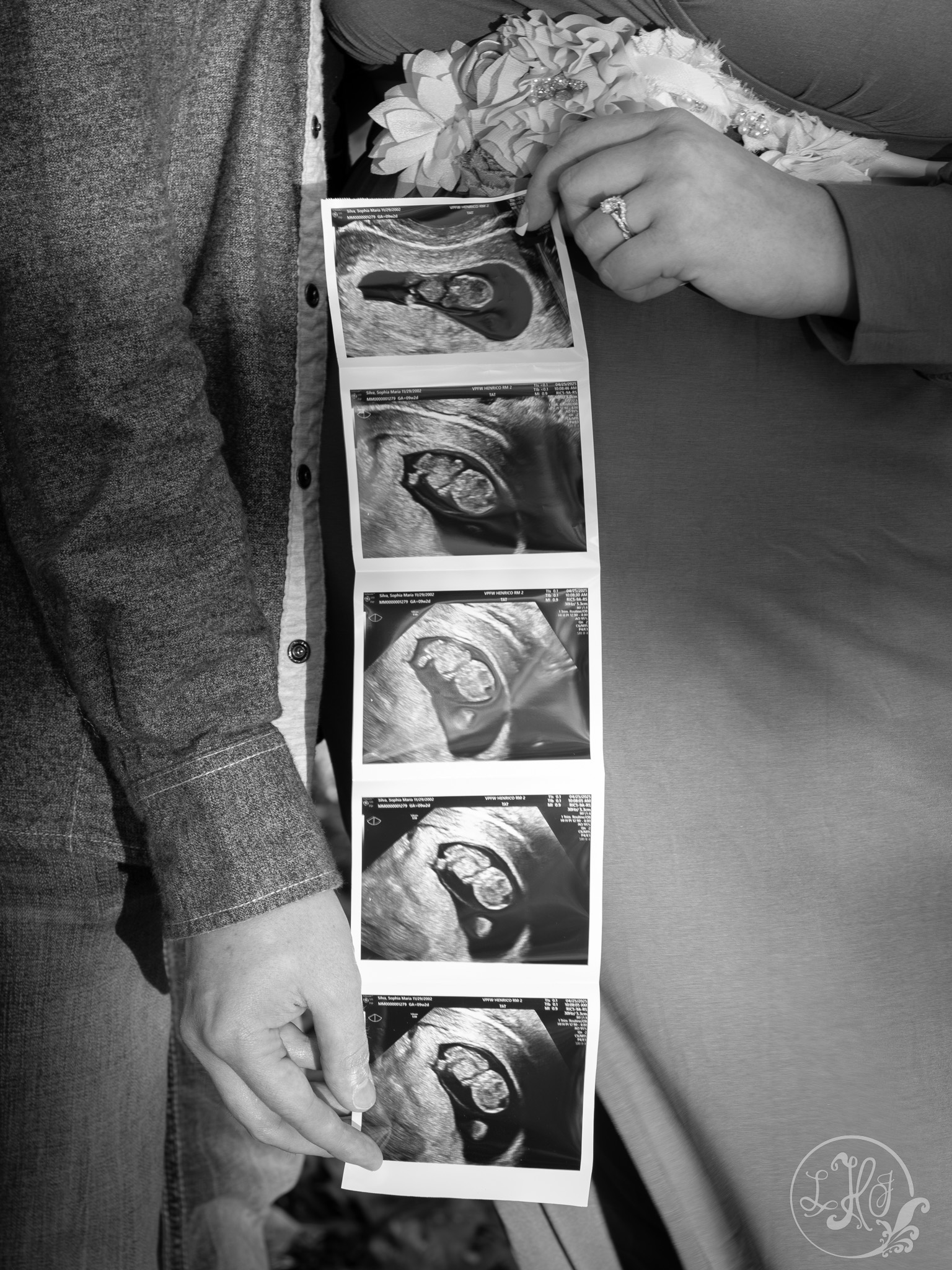 Black and White close up of expecting parents holding ultrasound photos