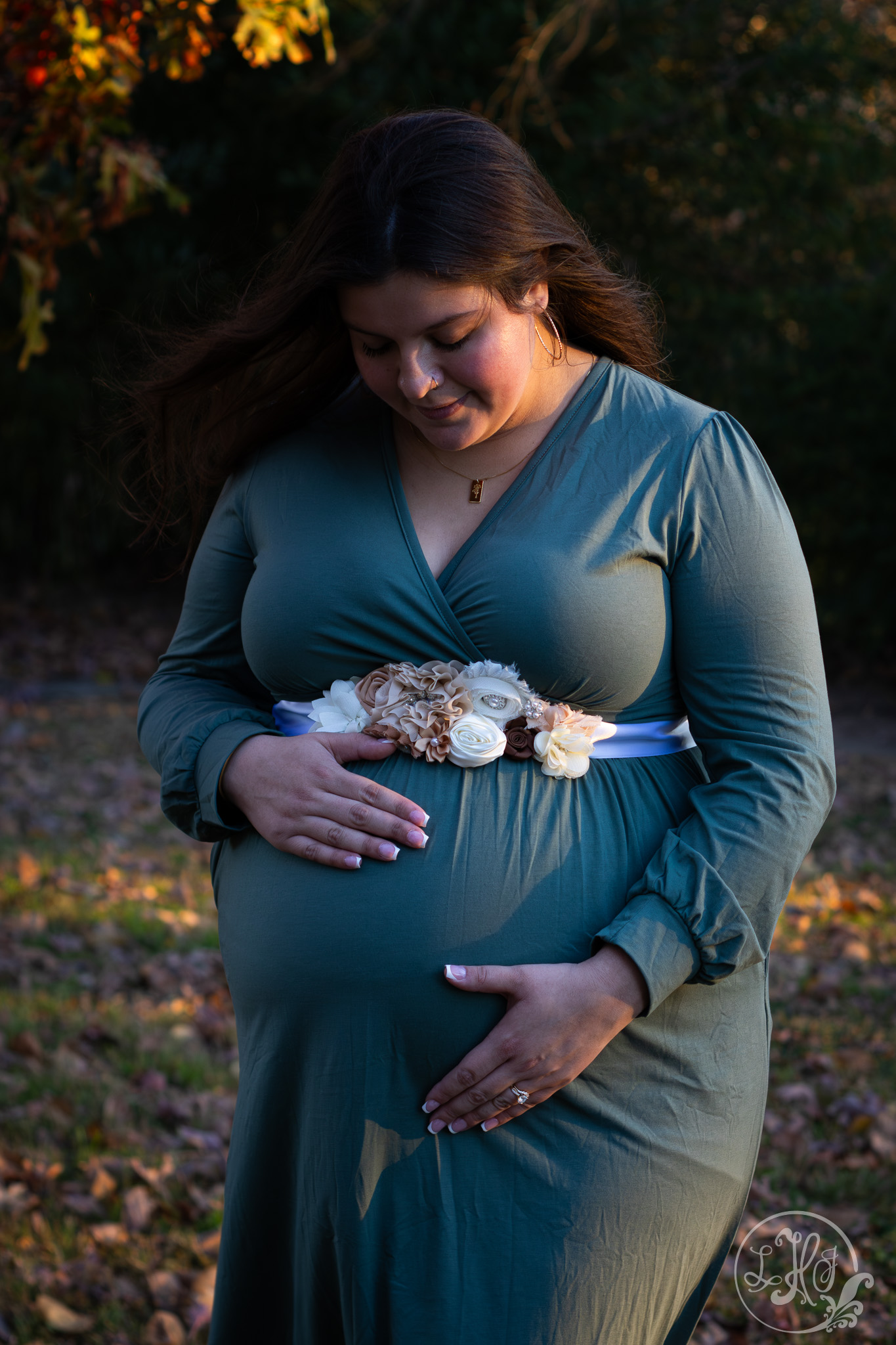 Expecting mother looking down at belly lovingly.