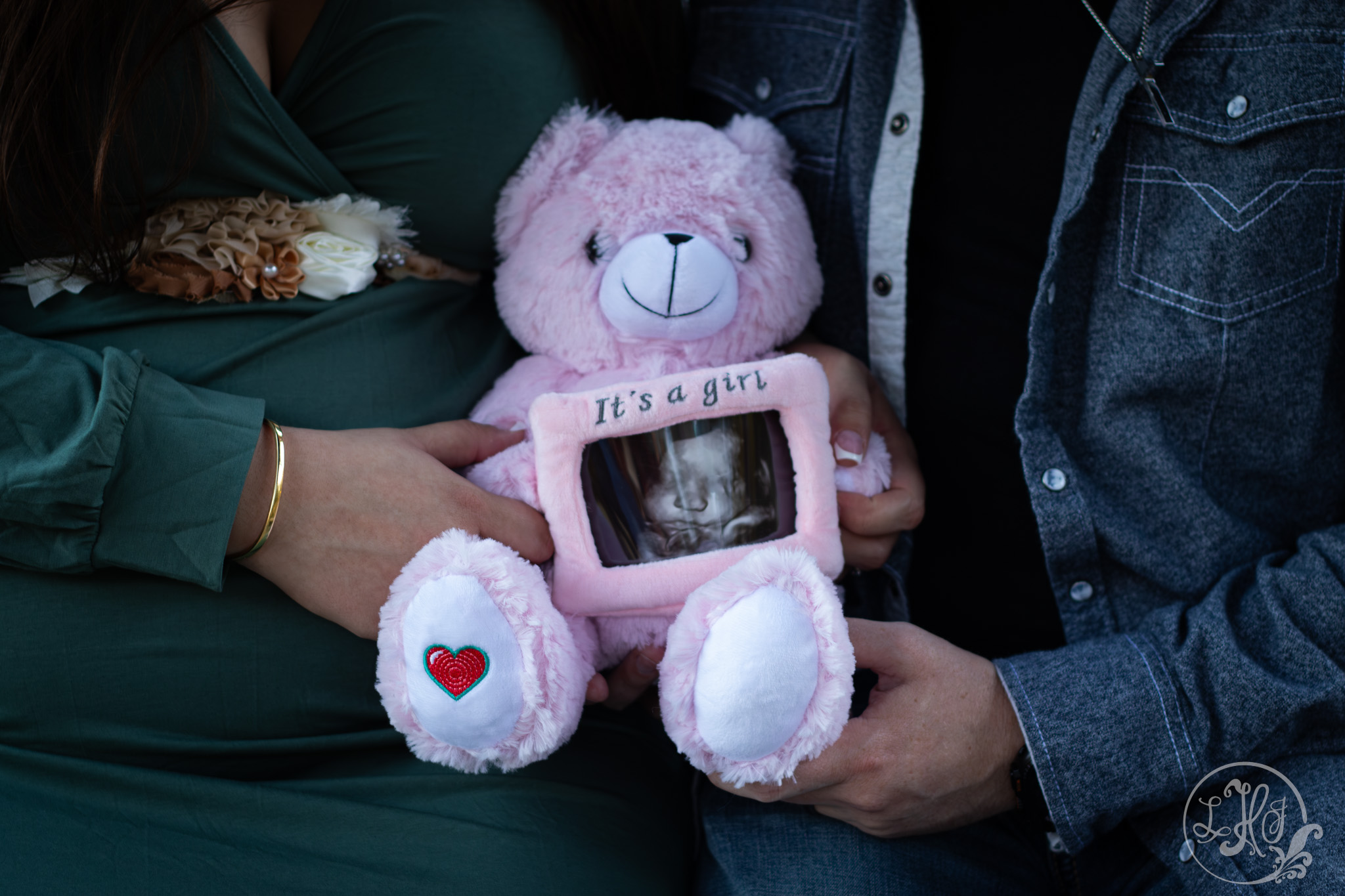 Close up of mom and dad to be holding bear with ultrasound photo