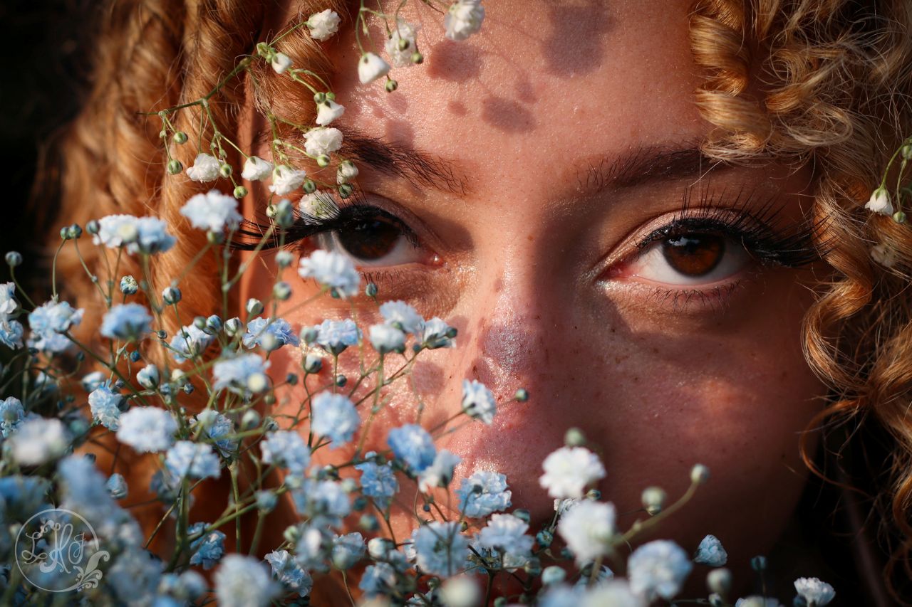 Close up photo of young woman's eyes and flowers